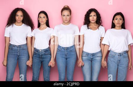 Unzufrieden Multiethnische Frauen Halten Hände Stehen Über Rosa Hintergrund Stockfoto
