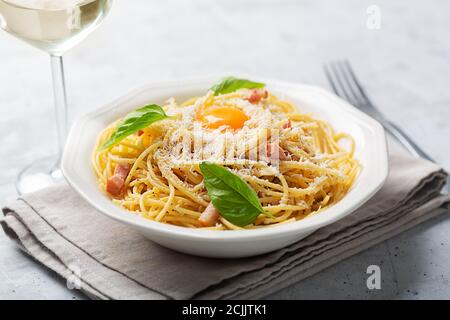 Italienische Pasta Carbonara mit Ei, Hartkäse, Schweinefleisch guanciale oder Pancetta und schwarzem Pfeffer. Betongrauer Hintergrund Stockfoto