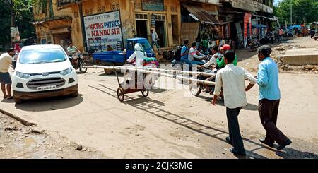 DISTRIKT KATNI, INDIEN - 18. SEPTEMBER 2019: Zwei indische Stromtafel Linemen Transport Bambustreppen auf der Straße Seite an Outdoor-Umgebung. Stockfoto