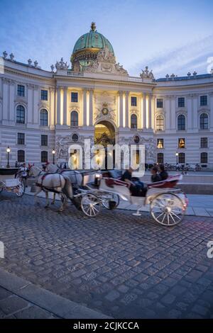 Pferd und Kutschen in der Hofburg in der Abenddämmerung, Wien, Österreich Stockfoto