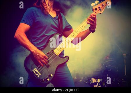 Gitarrist auf der Bühne mit Lichteffekten. Nahaufnahme mit Gitarre. Junger Musiker spielt Gitarre, Live-musikalischen Hintergrund. Band spielt auf der Bühne, Rockmusik Stockfoto