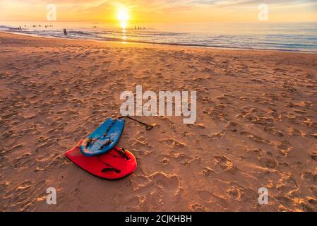 Schwimmen Bodyboards auf dem Sand bei Sonnenuntergang, Christies Beach, South Australia Stockfoto