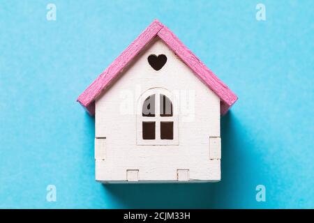 Kleines Spielzeughaus auf blauem Hintergrund, Draufsicht Stockfoto