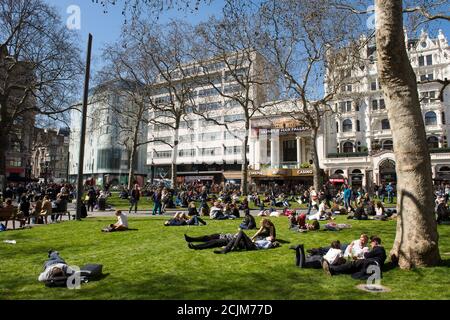 Menschen entspannen auf Leicester Square im West End von London, England. Stockfoto