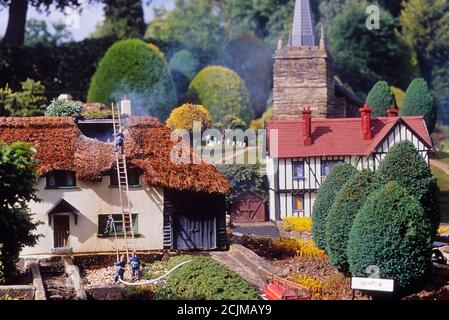 Modellfeuermänner Besuchen Sie ein Feuer in einem Reethaus in Hanton Weiler, Bekonscot Modelldorf und Eisenbahn, Bekonscot Modelldorf. Beaconsfield. Buckinghamshire, Chilterns, England, Großbritannien Stockfoto