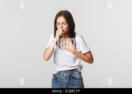 Junge Frau, die sich krank fühlt, hustet, hat covid-19 Symptome Stockfoto