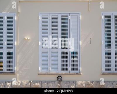 Mediterranes Holzfenster mit Fensterläden in der gelben Hauswand Stockfoto