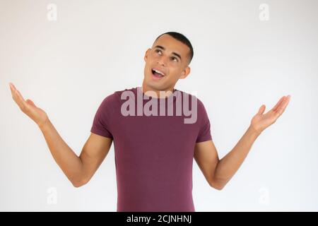 Schöner lateinamerikanischer junger Mann trägt lässige Kleidung ahnungslos und Verwirrter Ausdruck mit erhobenen Armen und Händen Stockfoto