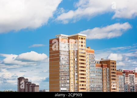 Neuer Block von modernen Apartments mit Balkon und blauem Himmel Mit weißen flauschigen Wolken im Hintergrund Stockfoto