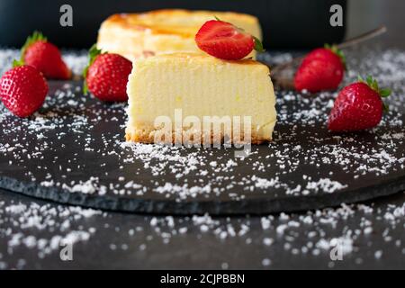 Kleiner Käsekuchen mit Erdbeeren auf dunklem Hintergrund Stockfoto