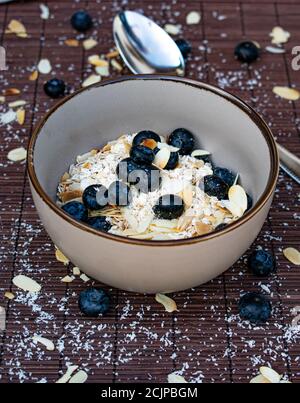 Haferflocken Müsli mit Beeren und Nüssen ohne Milch in einem Schüssel Stockfoto