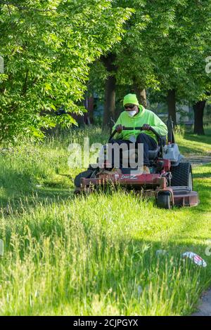 Detroit, Michigan - Arbeiter der Detroit Grounds Crew schneiden das Gras auf dem Gelände der Burbank School, einer von Dutzenden von geschlossenen öffentlichen Schulen i Stockfoto