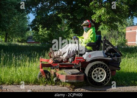 Detroit, Michigan - Arbeiter der Detroit Grounds Crew schneiden das Gras auf dem Gelände der Burbank School, einer von Dutzenden von geschlossenen öffentlichen Schulen i Stockfoto