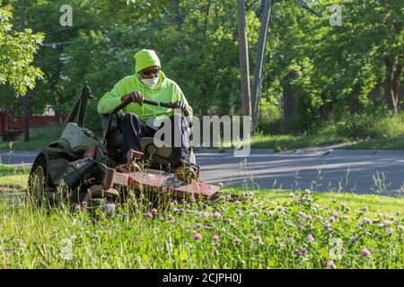 Detroit, Michigan - Arbeiter der Detroit Grounds Crew schneiden das Gras auf dem Gelände der Burbank School, einer von Dutzenden von geschlossenen öffentlichen Schulen i Stockfoto