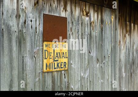 Rustikale graue Stallrost mit zwei Metallschildern, Knoten, Nägeln und Rost. Stockfoto