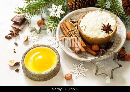 Saisonale Backen Winter Hintergrund. Zutaten für das Weihnachtsbacken - Schokolade, Gewürze, Nüsse, Mehl und Eier auf Steingrund. Stockfoto