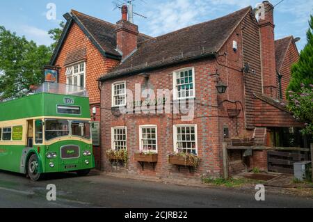 Das Sloop Inn Pub mit einem alten grünen Doppeldeckerbus, der vor dem Hotel in der Nähe von Scaynes Hill, West Sussex, Großbritannien, geparkt ist Stockfoto