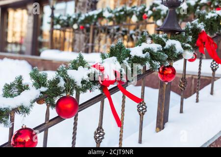 Weihnachten Stadtbild - Dekoration Geländer Veranda am Vorabend des Urlaubs. Weihnachtskugeln und Bänder. Winterurlaub. Stockfoto