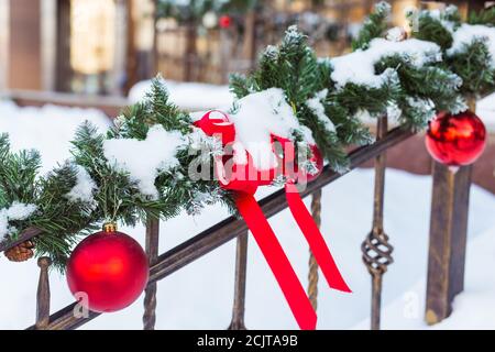 Weihnachten Stadtbild - Dekoration Geländer Veranda am Vorabend des Urlaubs. Weihnachtskugeln und Bänder. Winterurlaub. Stockfoto