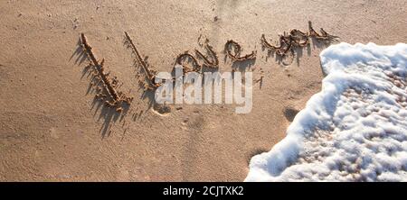 Ich liebe dich - eine Liebesbotschaft auf dem goldenen Sand mit einer Welle, die schäumt und wäscht die Beschriftung Stockfoto