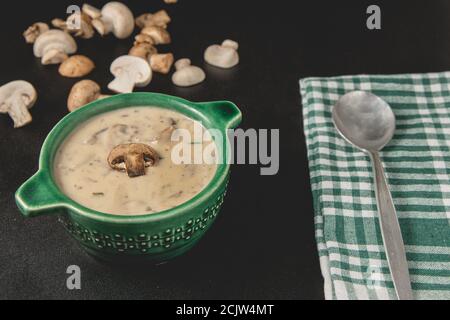 Hausgemachte Pilzsahnesuppe. Serviert auf dunklem Hintergrund. Nahaufnahme. Stockfoto