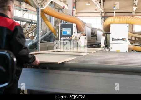 Riesige Arbeitsmaschine mit Spanplatte im Werk Stockfoto