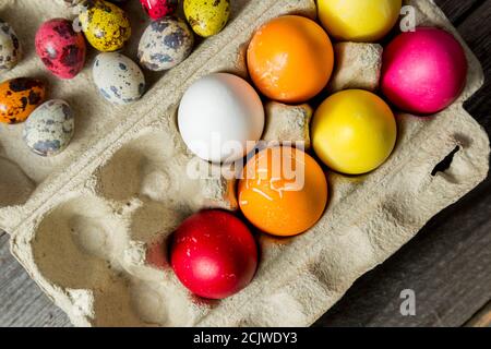 Gefärbte ostereier in Pappkarton auf Holzhintergrund. Stockfoto