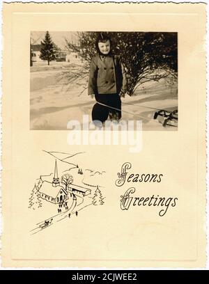 Season's Grußkarte eines Jungen mit seinem Schlitten im Schnee, 1947. Stockfoto