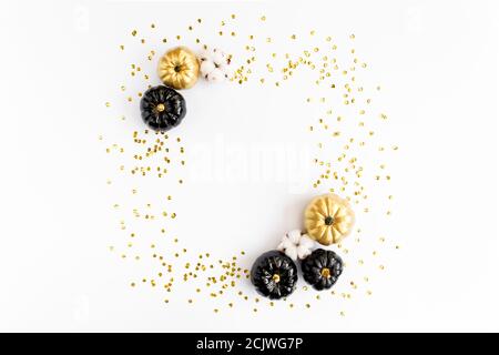 Goldrahmen verziert mit schwarzem und goldenem Halloween Kürbis und Lametta mit Platz für Text. Isoliert auf weißem Hintergrund. Flach liegend, Draufsicht. Stockfoto
