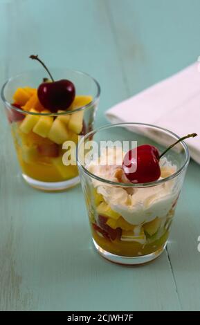 Frischer Obstsalat in zwei Gläsern auf rustikalem Holzhintergrund Stockfoto