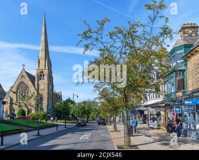 Christchurch Kirche und Geschäfte auf der Grove, der Hauptstraße in Ilkley, North Yorkshire, England, Großbritannien. Stockfoto