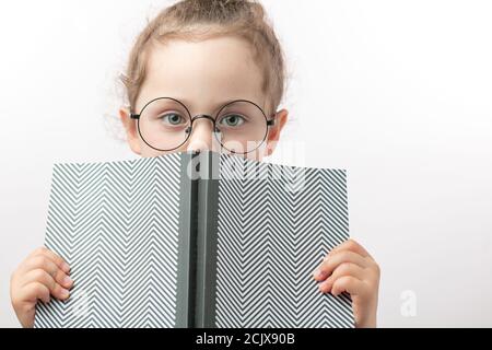 Schöne schlaue Mädchen mit grünen Augen vorgibt, ein Buch zu lesen. Isoliert weißen Hintergrund. Copyspace Stockfoto