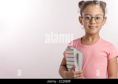 Schöne intelligente Schulmädchen hält einen Stapel von Büchern. Kostenlose Bildung.close up Porträt. Copyspace. Isolierte weißen Hintergrund Stockfoto