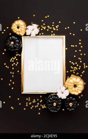 Goldrahmen verziert mit schwarzem und goldenem Halloween Kürbis und Lametta mit Platz für Text. Isoliert auf schwarzem Hintergrund. Flach liegend, Draufsicht. Stockfoto