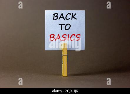 Weißes Papier mit Text 'zurück zu den Grundlagen', Clip auf Holz Wäscheklammer. Schöner grauer Hintergrund. Geschäftskonzept. Speicherplatz kopieren. Stockfoto