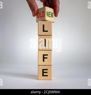 Hand dreht einen Würfel und ändert die Worte "altes Leben" in "neues Leben". Schöner weißer Hintergrund. Geschäftskonzept, Kopierbereich. Stockfoto