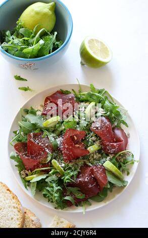 Carpaccio von Bresaola mit Rucola und Parmesan. Gesunde Ernährung Konzept. Draufsicht. Stockfoto