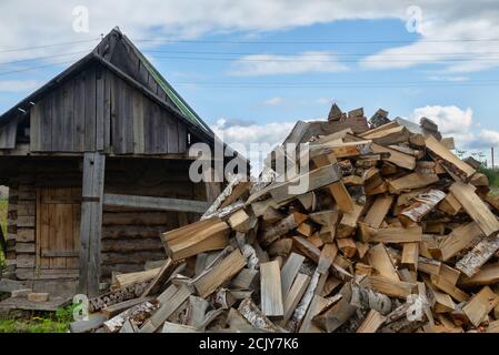 Holzheizung in Dorfhäusern und Bädern in Russland. Badehaus. Im Vordergrund ist Holzstapel aus Birkenholz (Birke gilt als High-ene Stockfoto