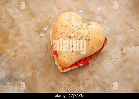 Herzförmiges Pizza-Teig-Sandwich mit Tomate, Mozzarella und Basilikum, Hochwinkelansicht Stockfoto