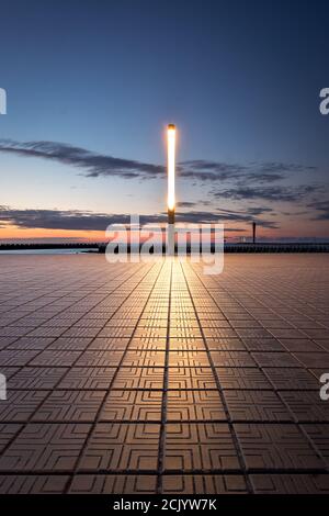 Lichtmast in der Nähe des Strandes von Ostend in Belgien gegen Sonnenuntergang Himmel. Stockfoto