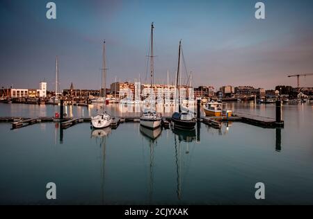 Segelboote in der Marina von Zeebrugge während der blauen Stunde. Langzeitbelichtung Stockfoto