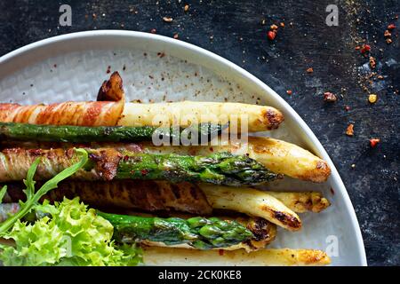 Reife gebackene Spargel mit Speck, Beilage zum Frühstück, Mittagessen, Grill. Stockfoto