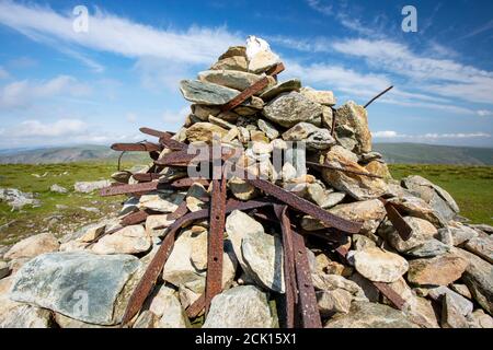 Alte rostende gusseiserne viktorianische Zaunpfosten in der Cairn auf harter fiel an der Spitze von Kentmere, Lake District, Großbritannien. Stockfoto