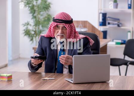Alter arabischer Geschäftsmann, der im Büro arbeitet Stockfoto