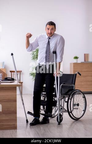 Junge behinderte Angestellte, die am Arbeitsplatz leiden Stockfoto