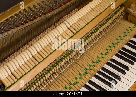 Das Innenleben eines aufrechten Klaviers, das die Streicher und Hämmer im Inneren zeigt. Stockfoto