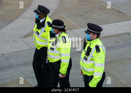 Polizisten mit Gesichtsmasken auf dem Trafalgar Square in London, England Großbritannien Stockfoto