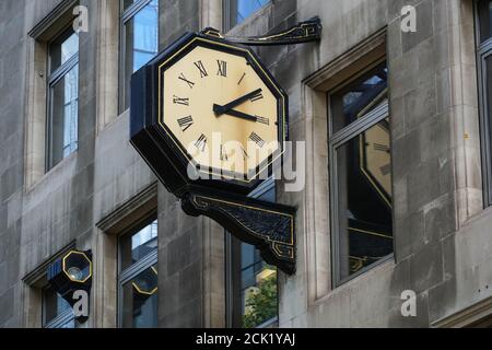 Straßenuhr hängt an der Wand eines Gebäudes in London England Vereinigtes Königreich Großbritannien Stockfoto