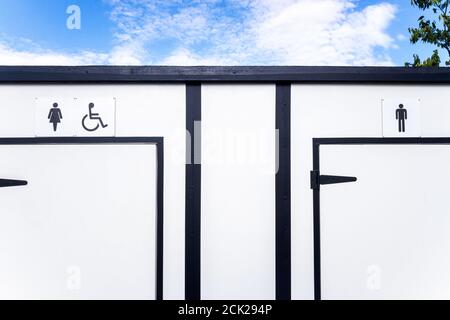 Weiße tragbare Toiletten mit Platz für Frauen, Männer und Behinderte. Stockfoto