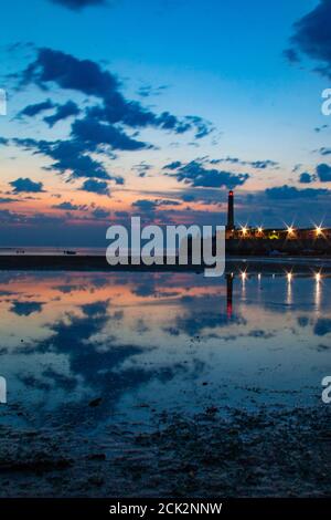 Wunderschöne Spiegelung des Sonnenuntergangs und des Leuchtturms bei Ebbe am Margate Harbour Arm - Margate, Thanet, Kent, England, Vereinigtes Königreich Stockfoto